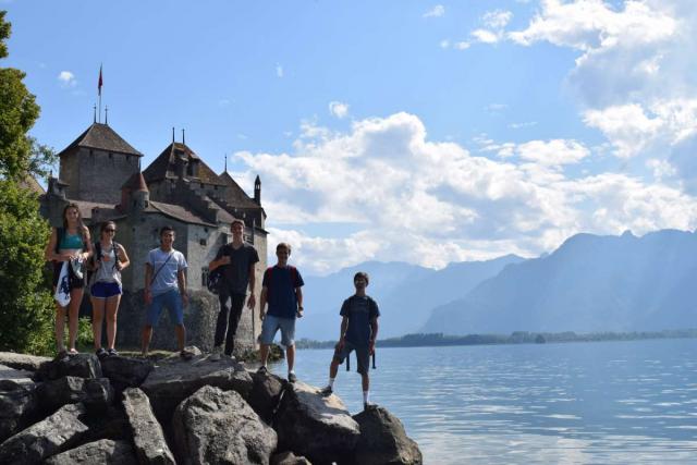 Teens swimming in Switzerland alpine lake on youth travel tour