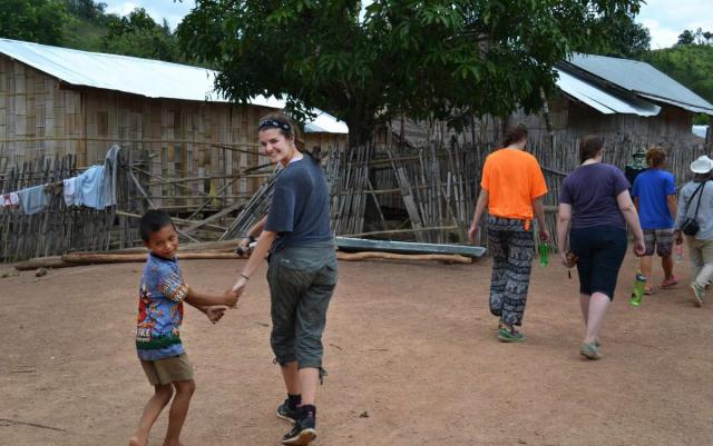 Teenage travelers with local children during summer youth travel program in Thailand