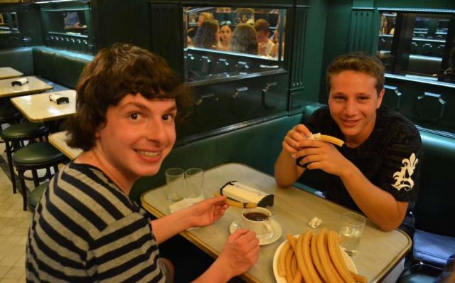 Teenage travelers eat churros and chocolate in Madrid on summer youth travel program