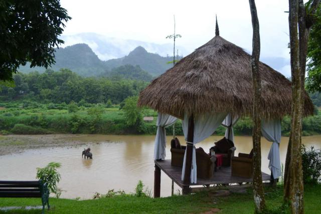 View of thatched roof hut and river seen by teenage travelers during summer youth program in Southeast Asia