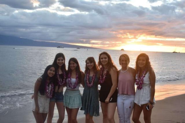 Students enjoy the sunset on a beach in Hawaii on summer teen service program.