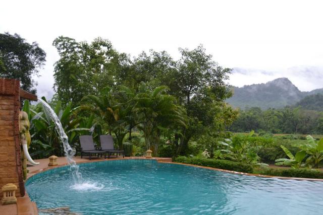 Pool and waterfall and mountains seen by teenage travelers during summer youth program in Southeast Asia