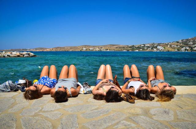 High school travelers relax on the seaside in Greece on their summer teen tour.