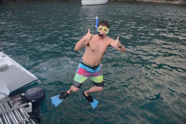 Teen jumps into the water to snorkel on summer adventure program in Costa Rica.