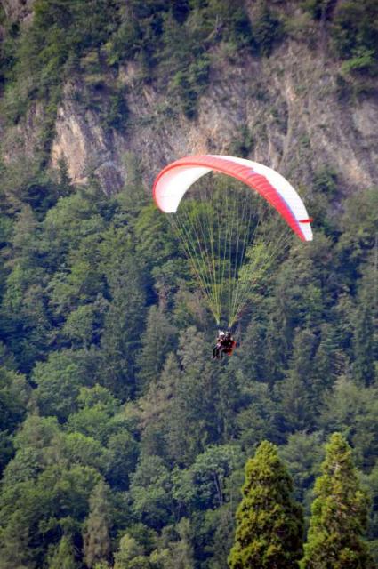 Teenage travelers paraglide in Interlaken on summer youth adventure program
