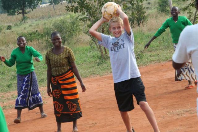 Teens participate in games with host students during service program in Tanzania.