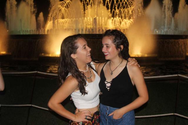 Teenage travelers laugh at Barcelona Magic Fountain of Montjuic during summer Spanish language immersion program