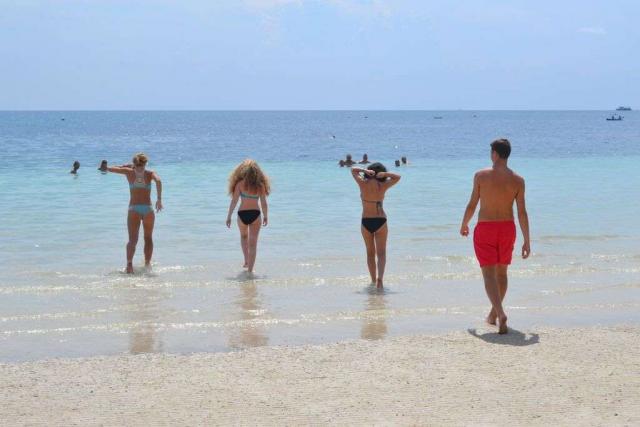 Teenage travelers go swimming in the Pacific ocean during summer youth program in Southeast Asia