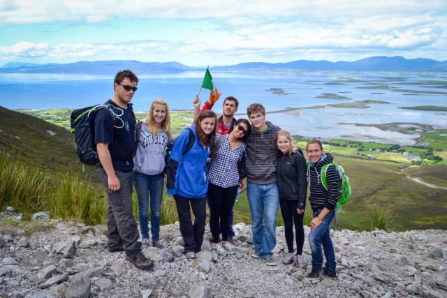 Teen travelers hike Croagh Patrick during summer youth adventure travel program in Ireland