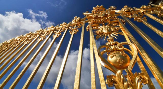 Golden gates of Chateau de Versailles visited by teen travelers on French language immersion program in Paris