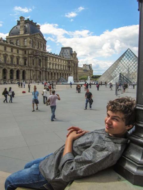 Teen traveler relaxes at Louvre Museum on summer student travel program in France