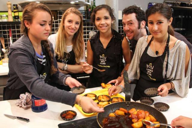 Teenage travelers at cooking lesson in Paris during French summer language immersion program