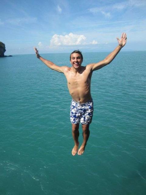 Teenage boy jumps into water during summer youth program in Southeast Asia