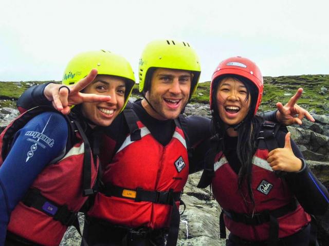 Teen travelers coasteering in Ireland during summer youth adventure travel program