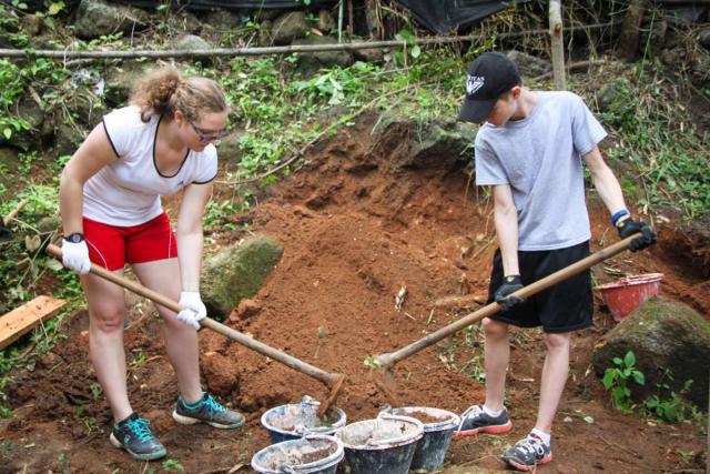 Teenage travelers volunteering doing community service during summer youth travel program in Thailand