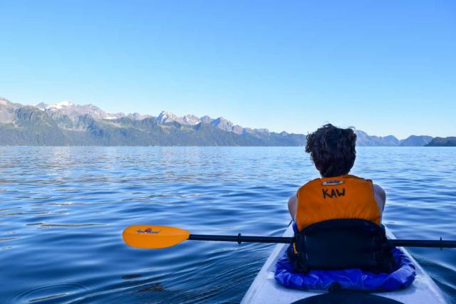 Teenage traveler kayaking Alaska on summer travel program