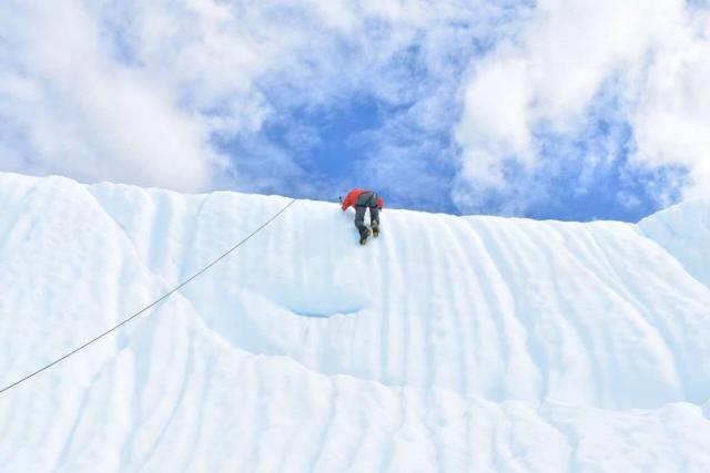 Teen traveler ice climbing in Alaska on summer program
