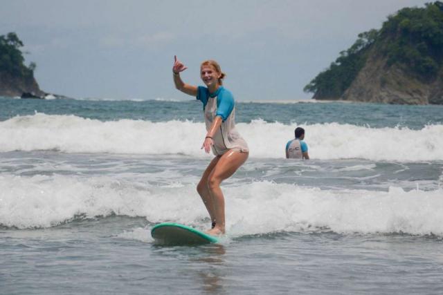 A teen learns how to surf on a travel adventure tour of Costa Rica.