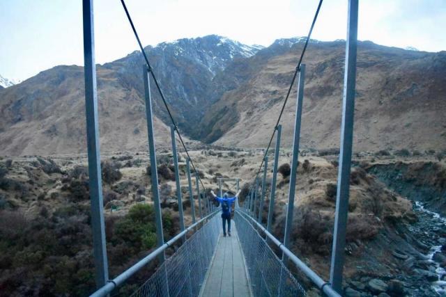 Teenage traveler crosses bridge during summer youth travel program in New Zealand