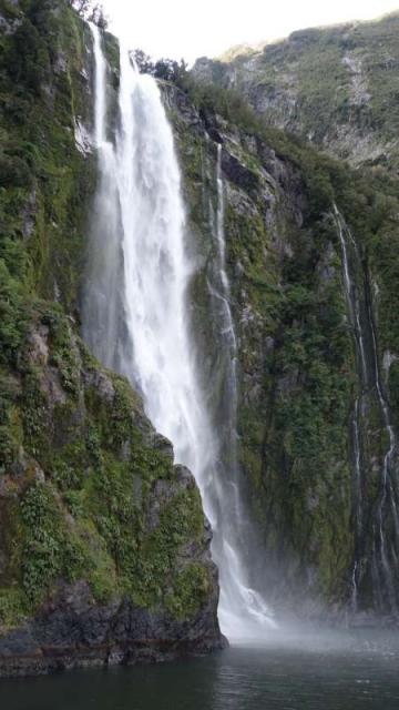 Scenic waterfall seen by teenage travelers during summer youth travel program in New Zealand