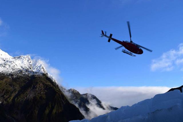 Teenage travelers take helicopter tour during summer youth travel program in New Zealand