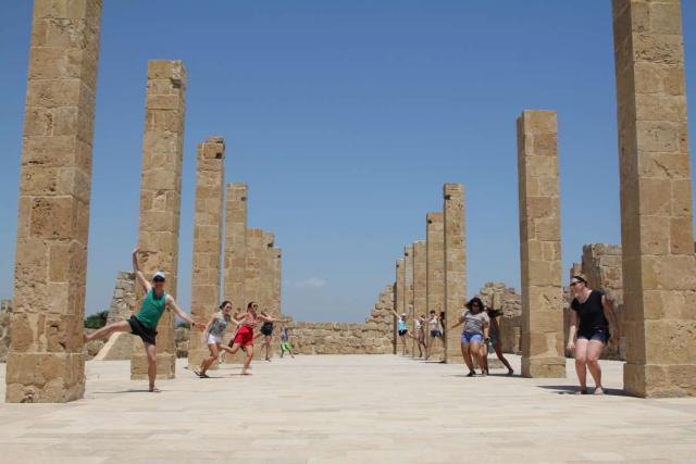 Happy teenage travelers explore archaeological ruins in Sicily Italy during summer youth travel program