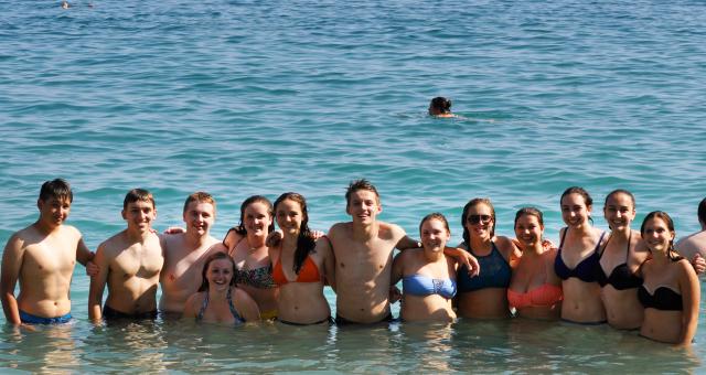 Teenage travelers swim in Mediterranean Sea in Cinque Terre during summer travel photography program