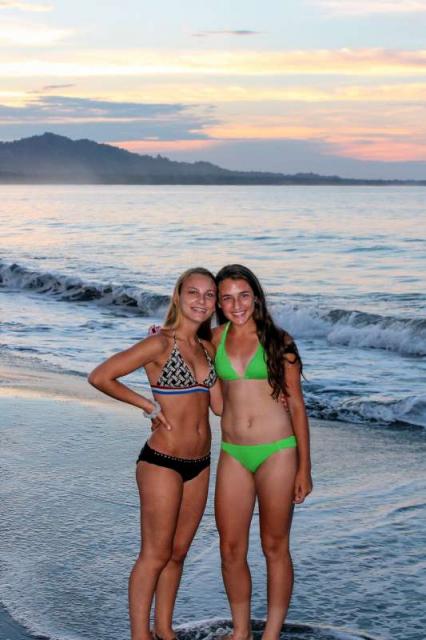 Teens girls enjoy the sunset at the beach on their summer travel tour in Costa Rica.