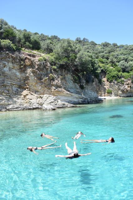 Teenage travelers swim in Mediterranean Sea during summer youth travel program in Greece