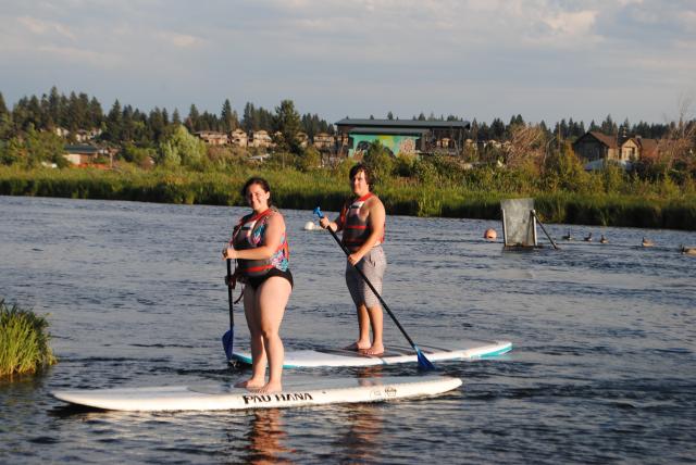 Students go stand-up paddle boarding on their summer teen tour of North America.