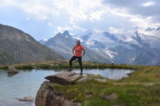 Teen traveler at Alpine lake in Swiss Alps during summer youth adventure travel program