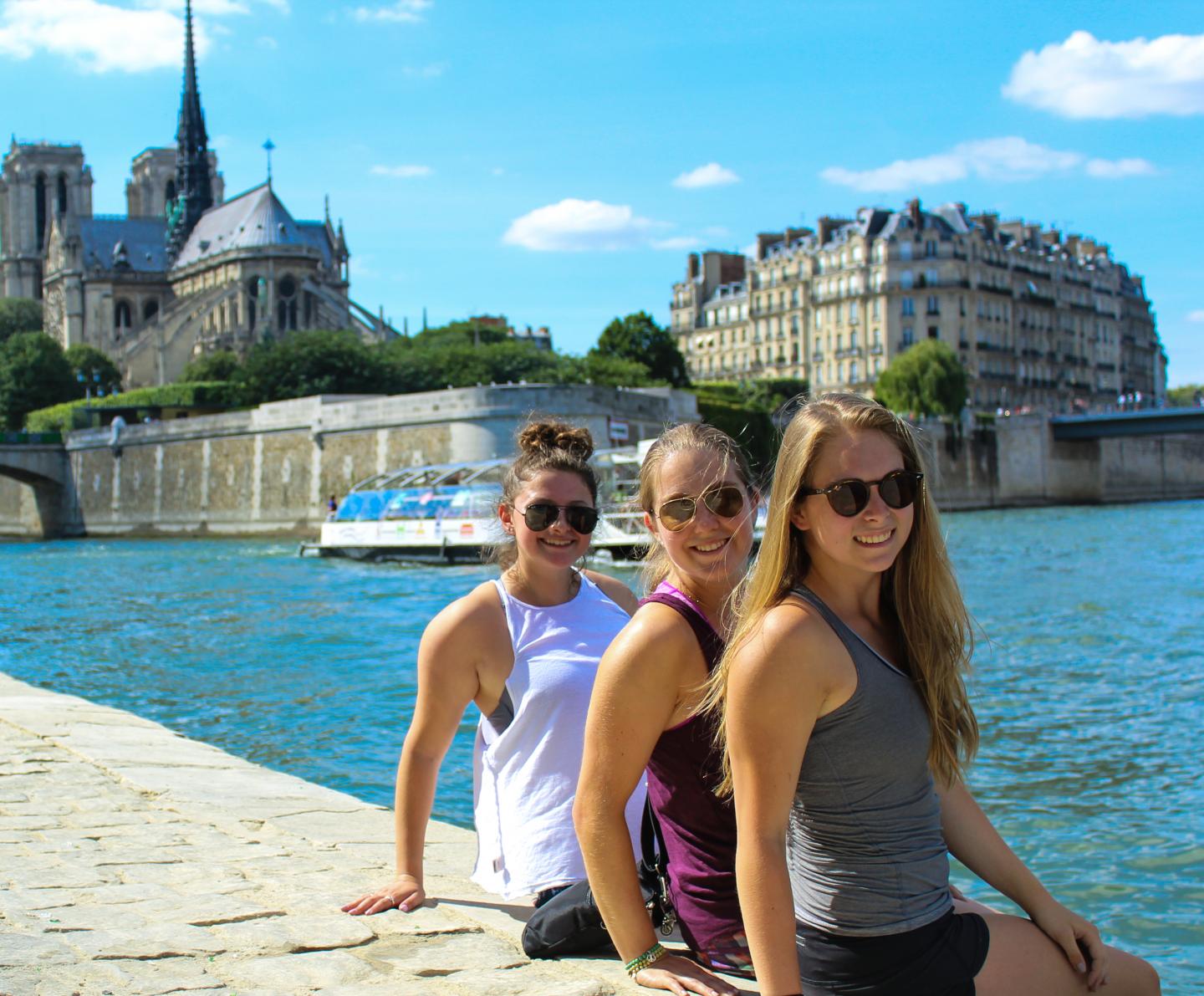 Teenage travelers relax at Notre Dame River Seine on Paris youth summer travel program