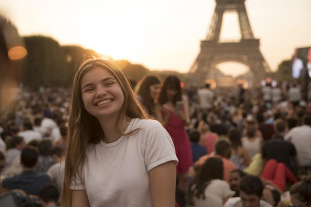 Teenage traveler with Eiffel Tower at sunset on summer photography program in Paris