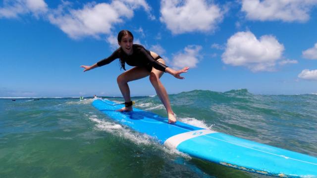 teen girl surfs in Hawaii