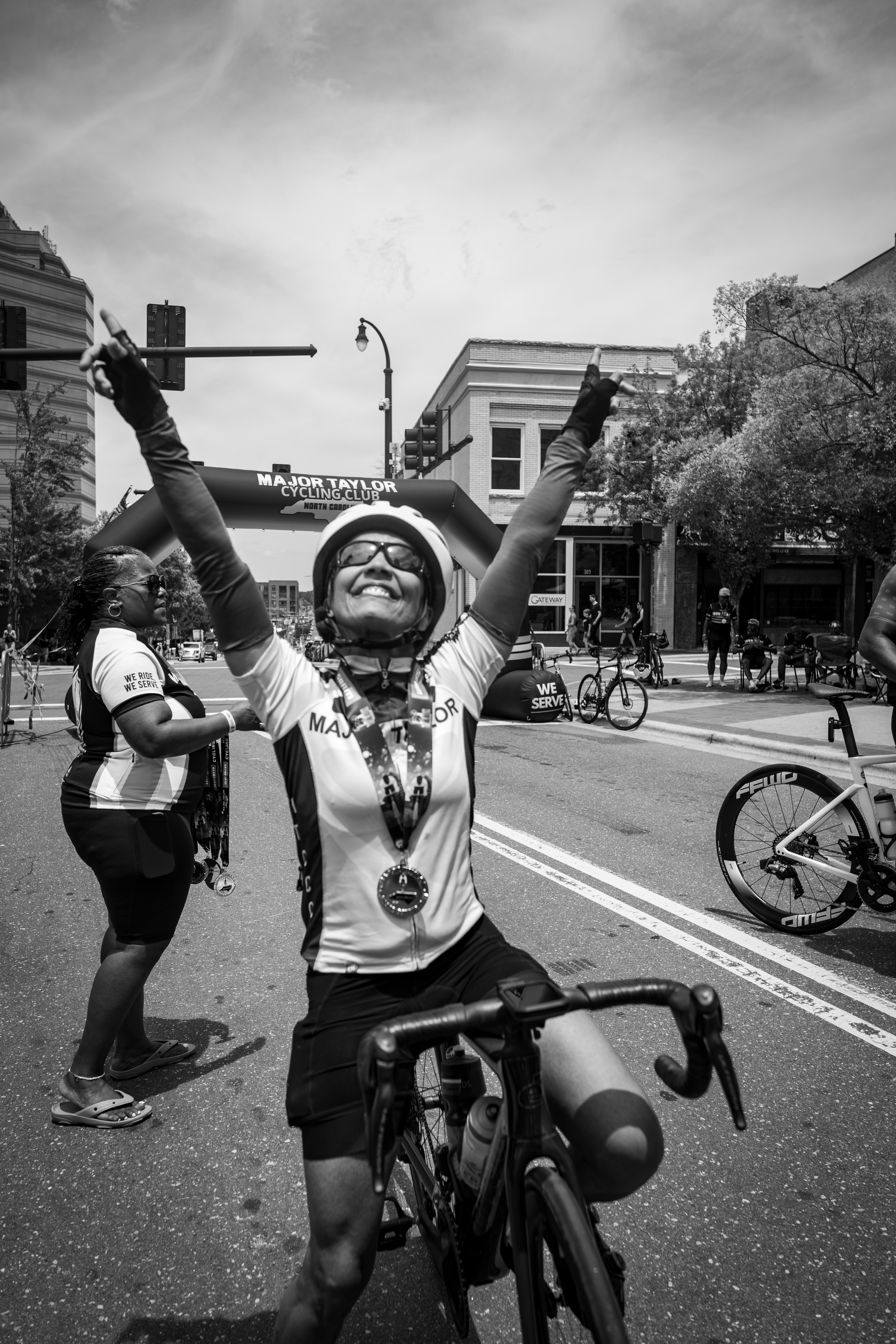 A cyclist crossing the finish line with both arms raised