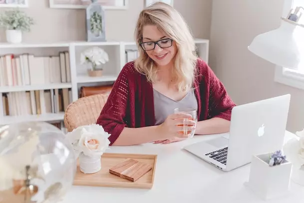 female content creator holding glass cup of tea