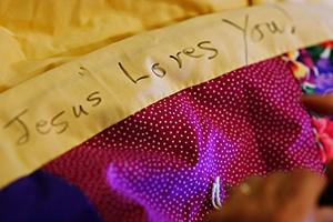 Each quilt Delores sews says "Jesus Loves You"