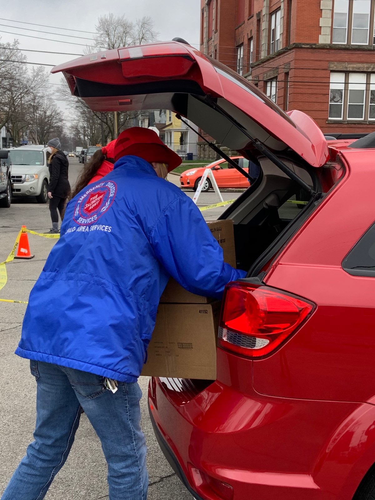 Volunteer loading box into car