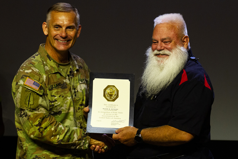 Superintendent, Lt. Gen. Steven Gilland (left), awards Peter D. Hanlon (right), an associate professor in the Department of Electrical Engineering and Computer Science, with a certificate in recognition of 40 years of service to the government during the  award ceremony Aug. 10 at the U.S. Military Academy.