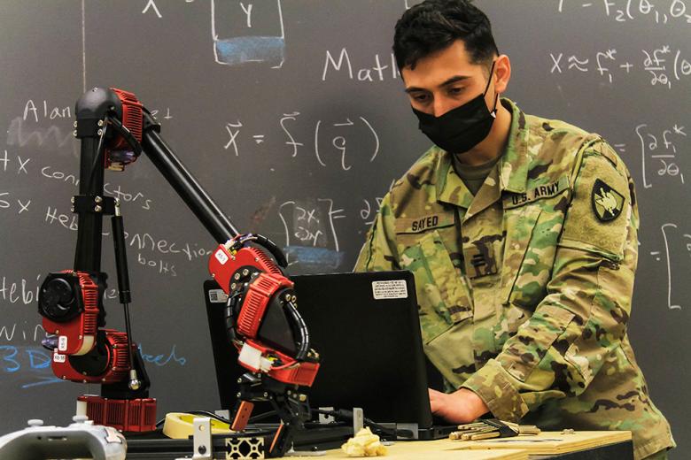 Class of 2021 Cadet Andreas Sayed is going over data for the robotic module called “the arm” during Academic Majors Open House. 