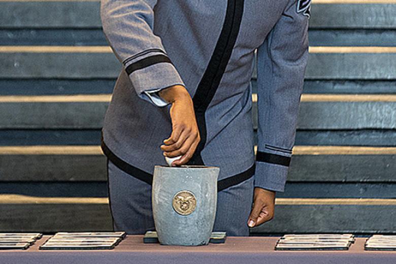 Class of 2022 Cadet and Class President Xavier Williams places a ring, one of 52 donated rings, in the crucible.