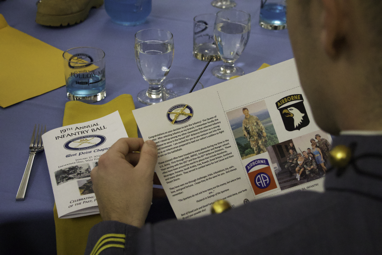 A cadet receives a pair of crossed rifles along with a personal note from a senior Infantry Officer as part of the Keep Up the Fire program that occurs at every Infantry Ball. This event helps instill the pride for the branch on the newest Officers from those Officers and NCOs who currently serve or have served in the past.
