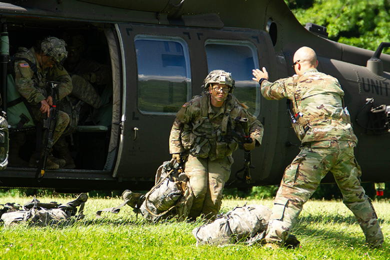 Capt. Curt Lane (Right, standing) directed Class of 2024 cadets as they exit the helicopter at Landing Zone OWL and get in defensive positions on the last day of the field training exercise June 23 at Camp Buckner.   	
