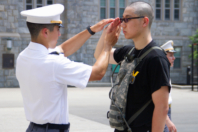 A U.S. Military Academy at West Point junior teaches a new cadet how to salute during Reception Day Monday.        Photo by Jorge Garcia/PV
