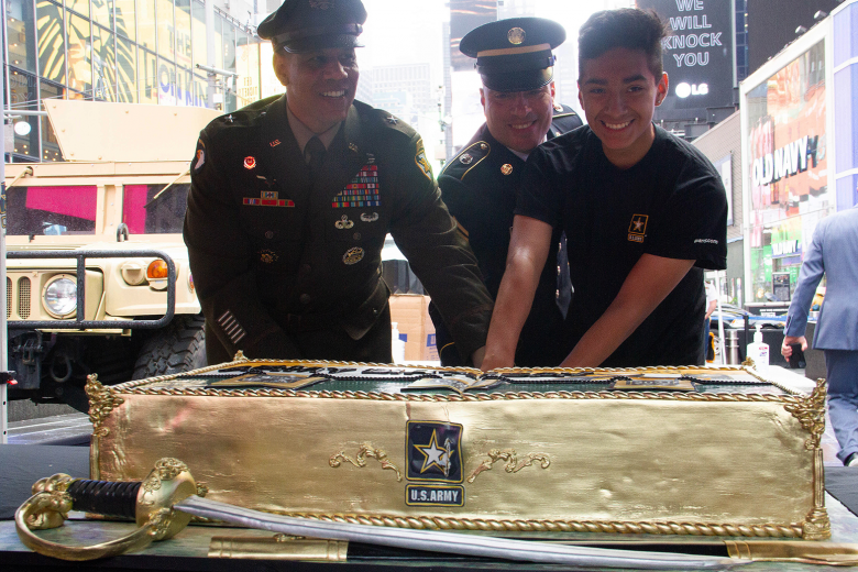 Commandant of the Corps of Cadets, Brig. Gen. Mark Quander, cuts a cake with the youngest and oldest military service members in attendance during the 246th Army Birthday celebration Monday at Times Square in New York City.      		