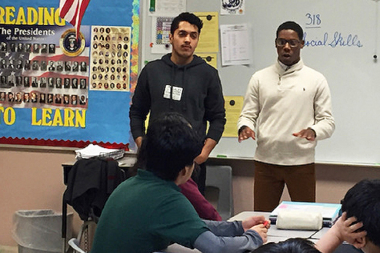 Class of 2022 Cadet Zorian Flowers (right) visiting his former middle school, Richard J. Daley Elementary Academy, in Chicago during the 2010s, with his colleagues, to provide younger students with advice on what to look forward to as high school students.     Courtesy Photo