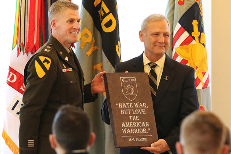 In attendance was retired Col. David Moore (right), son of Lt. Gen. Moore, with the Department of Physical Education Head, Col. Nicholas Gist (left), as they hold a plaque with a quote from Hal Moore.	    