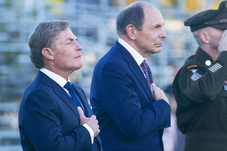 From left to right, Thayer Award recipient Kenneth Fisher and USMA Class of 1975 graduate Robert McDonald place their hands over their hearts as they watch the review, in which the Corps of Cadets march on the Plain honoring the Thayer Award recipient.