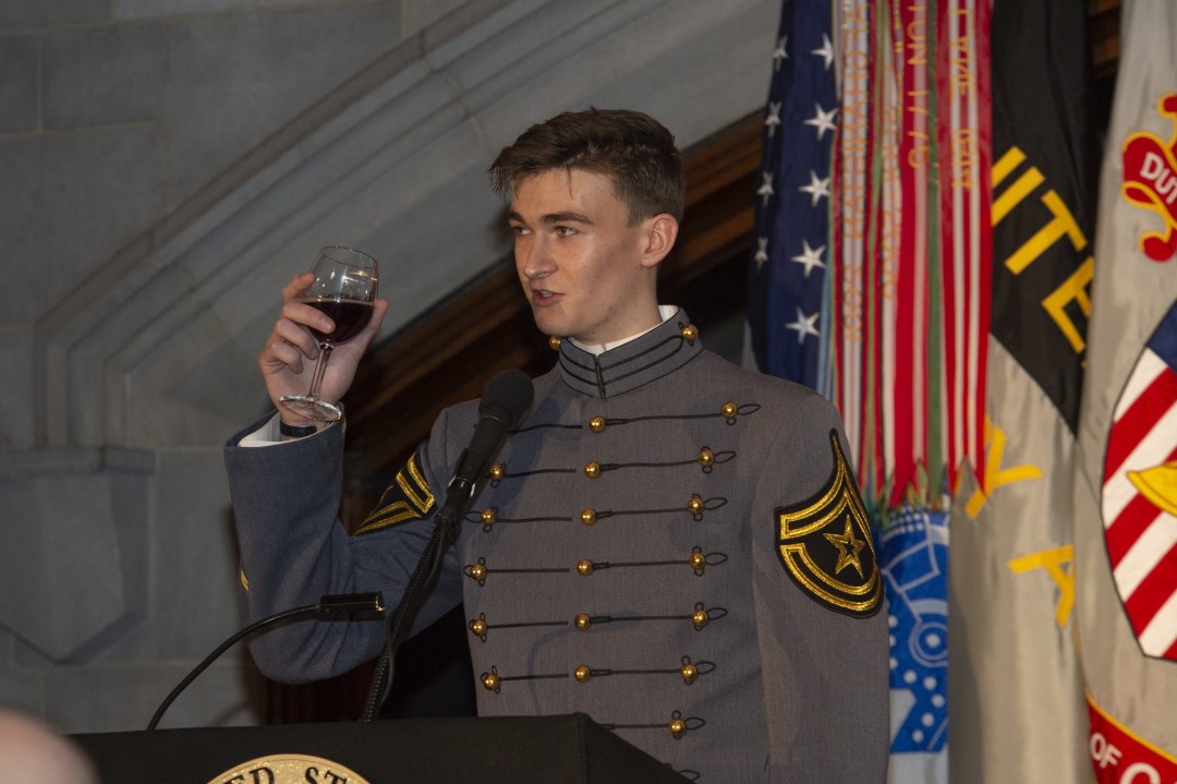 A cadet raises his glass to salute his class