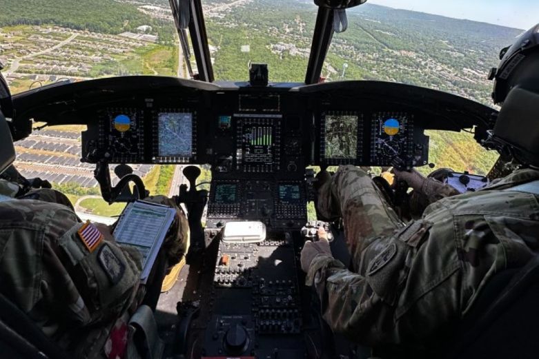 Two people look through a cockpit window